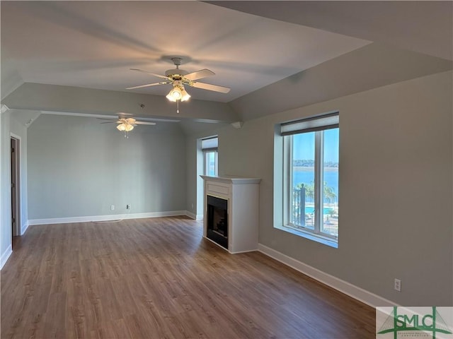 unfurnished living room featuring lofted ceiling, hardwood / wood-style floors, and ceiling fan