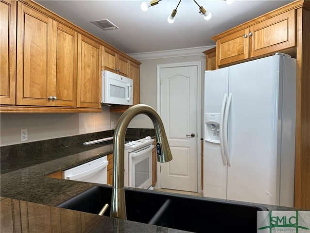 kitchen featuring ornamental molding, white appliances, and dark stone counters