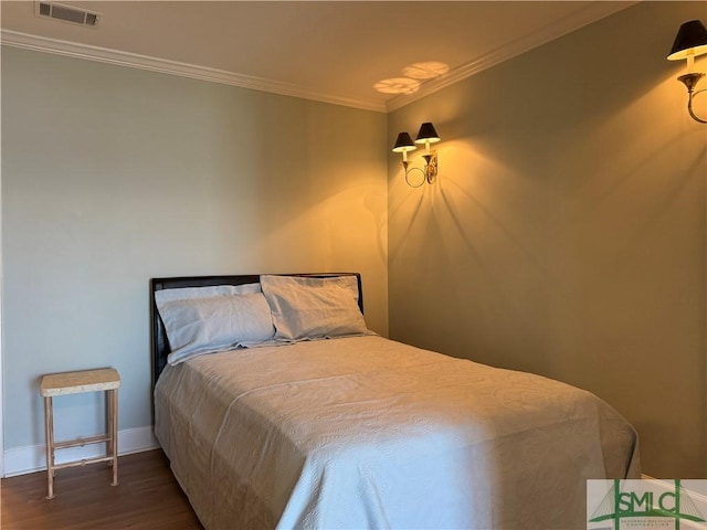 bedroom with dark wood-type flooring and ornamental molding