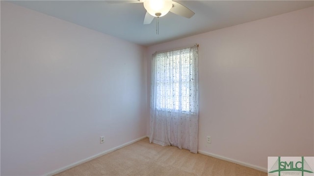 empty room featuring light colored carpet and ceiling fan