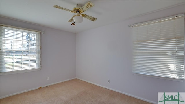 carpeted spare room featuring ceiling fan