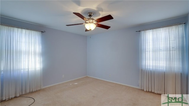 unfurnished room with ceiling fan, light colored carpet, and a healthy amount of sunlight