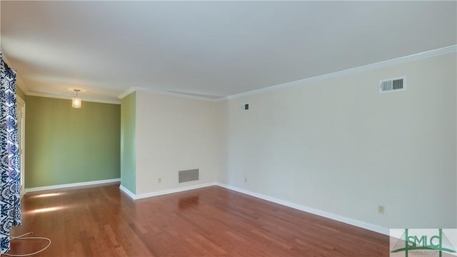 empty room featuring ornamental molding and hardwood / wood-style floors