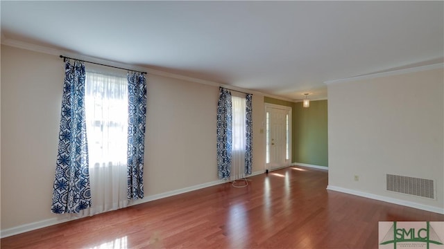 unfurnished room featuring hardwood / wood-style floors and ornamental molding