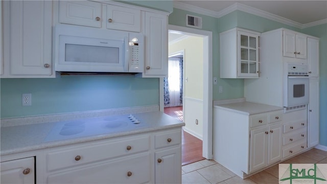 kitchen with light tile patterned floors, white cabinets, and white appliances