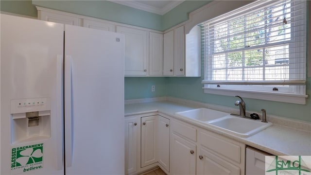 kitchen featuring sink, ornamental molding, white fridge with ice dispenser, and white cabinets