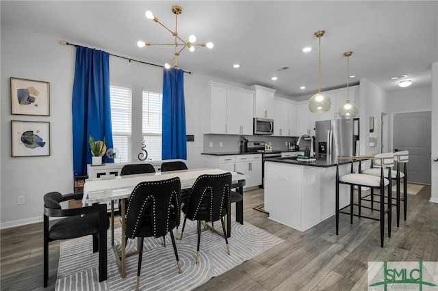 dining room featuring a chandelier, sink, and light wood-type flooring