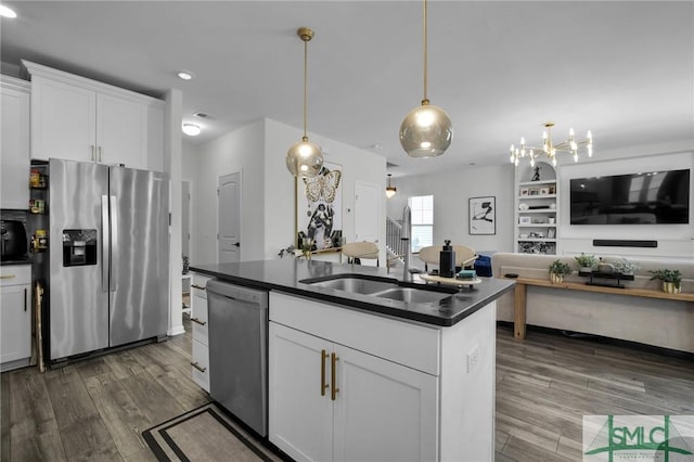 kitchen featuring stainless steel appliances, a kitchen island with sink, sink, and white cabinets