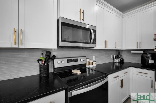 kitchen with decorative backsplash, white cabinets, and appliances with stainless steel finishes