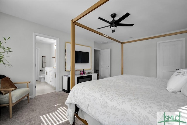 bedroom featuring light colored carpet, ceiling fan, and ensuite bathroom