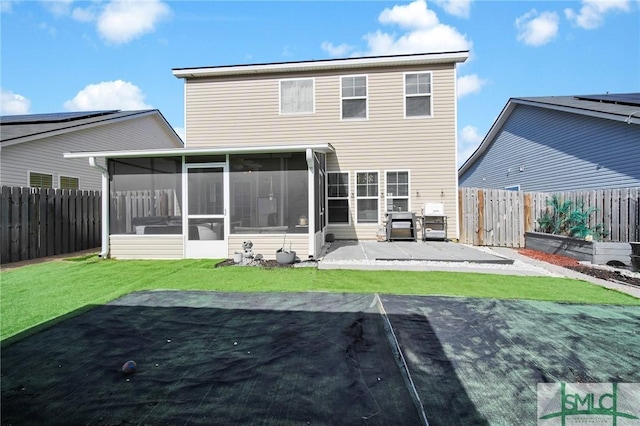 back of property featuring a yard, a sunroom, and a patio