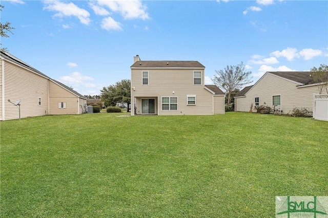 rear view of house featuring a yard