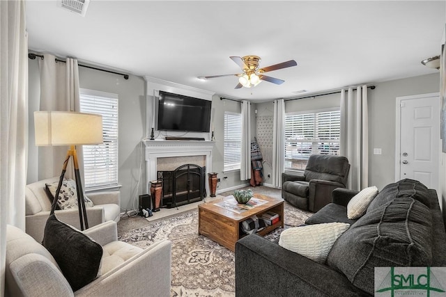 living room featuring a high end fireplace and ceiling fan