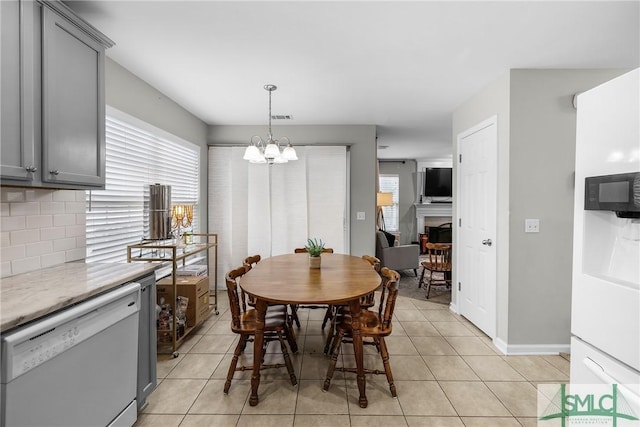 tiled dining room featuring an inviting chandelier