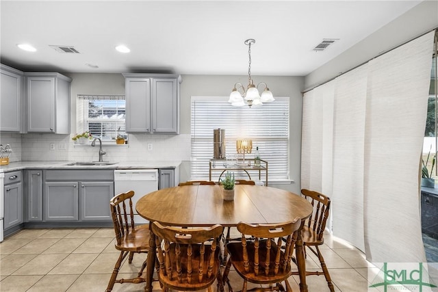 tiled dining room featuring a chandelier and sink