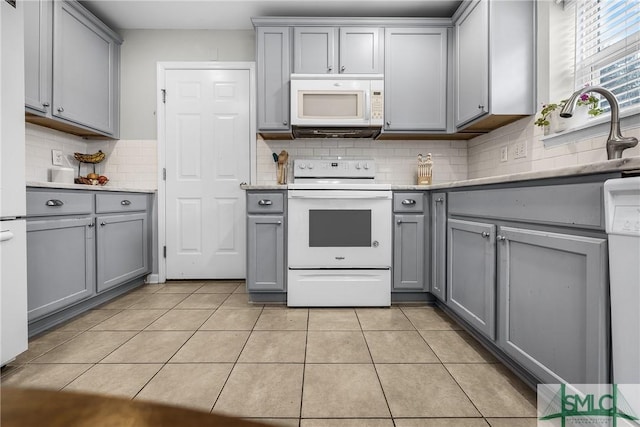 kitchen with backsplash, white appliances, gray cabinets, and light tile patterned flooring