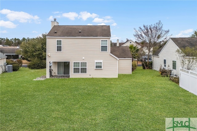 rear view of property featuring central AC unit and a lawn