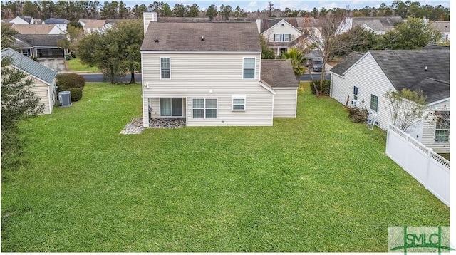 rear view of house with a yard and central AC unit