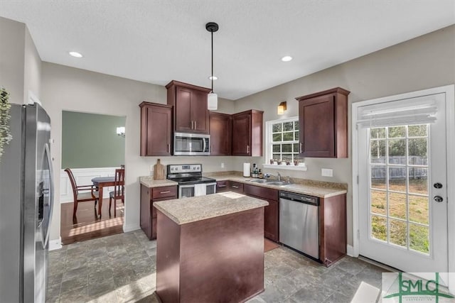 kitchen with pendant lighting, sink, a center island, and appliances with stainless steel finishes