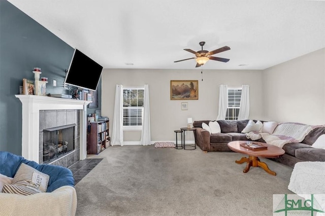 carpeted living room with a fireplace and ceiling fan