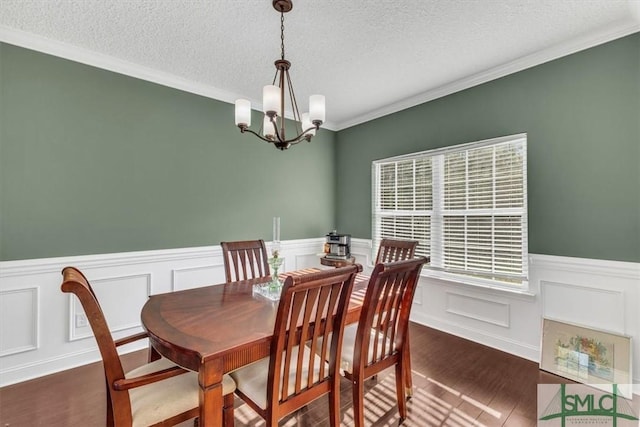 dining area with a notable chandelier, crown molding, dark hardwood / wood-style floors, and a textured ceiling