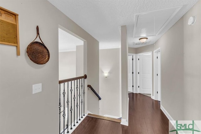 hall featuring dark wood-type flooring and a textured ceiling