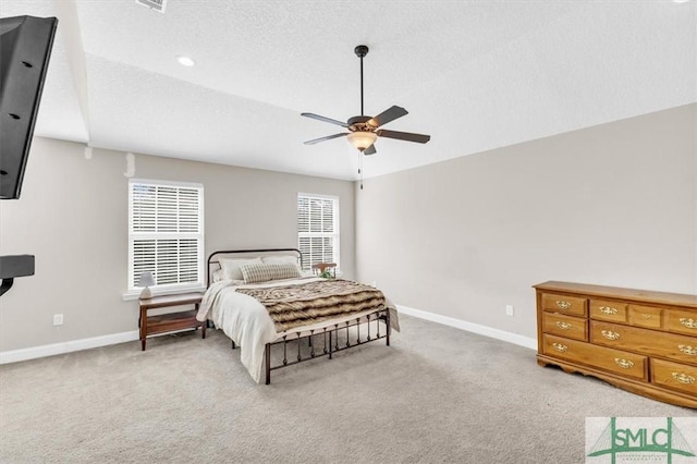 bedroom featuring light carpet, ceiling fan, and a textured ceiling