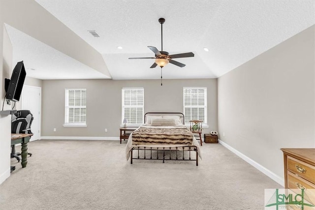 carpeted bedroom with multiple windows, vaulted ceiling, and a textured ceiling