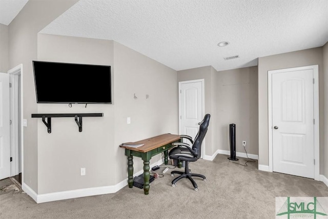 office space featuring light carpet and a textured ceiling