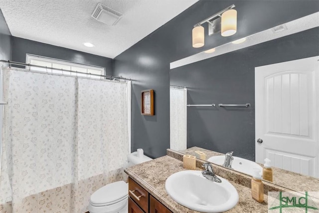 bathroom featuring vanity, toilet, and a textured ceiling