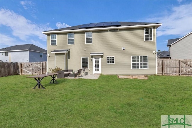 rear view of property with an outdoor living space, a yard, a patio, and solar panels