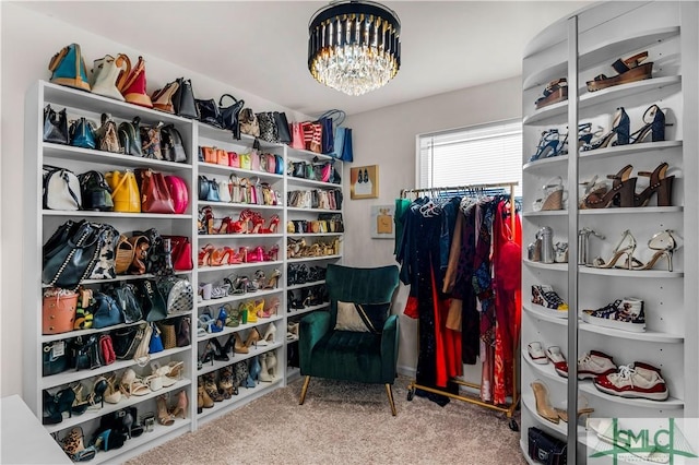 spacious closet with carpet floors and a chandelier