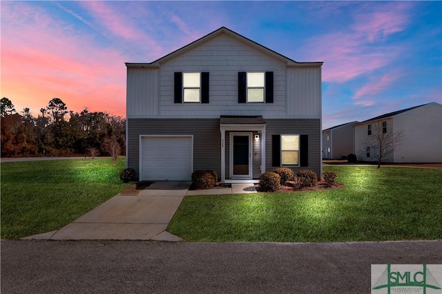 front of property with a garage and a lawn