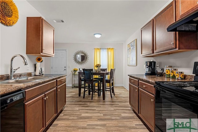 kitchen featuring sink, ventilation hood, black appliances, and light hardwood / wood-style floors