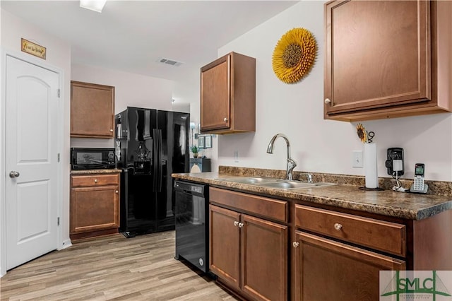 kitchen with sink, light hardwood / wood-style flooring, and black appliances