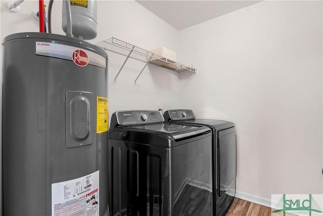 washroom featuring independent washer and dryer, electric water heater, and hardwood / wood-style floors