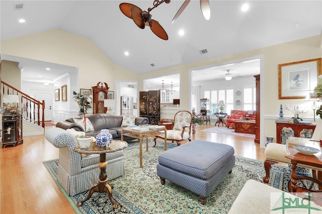 living room featuring ceiling fan, lofted ceiling, and light wood-type flooring