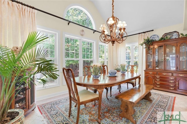 dining area with light tile patterned floors, a notable chandelier, and high vaulted ceiling