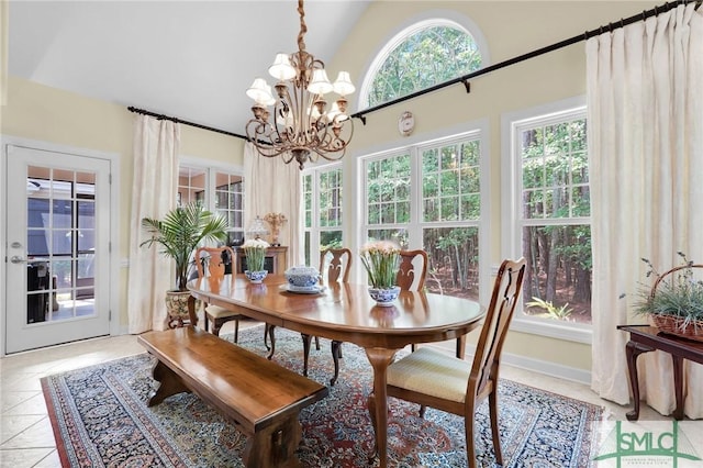 tiled dining area with vaulted ceiling and a notable chandelier