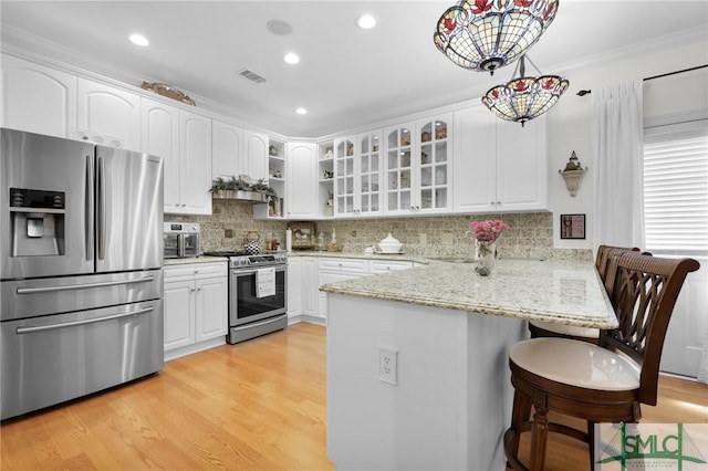 kitchen with white cabinetry, hanging light fixtures, stainless steel appliances, and kitchen peninsula