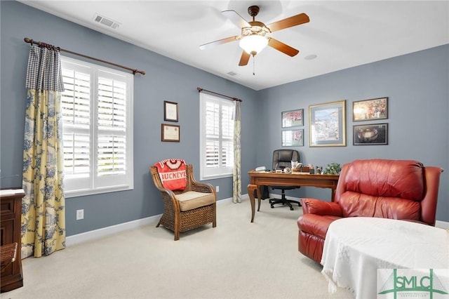 carpeted office space featuring ceiling fan