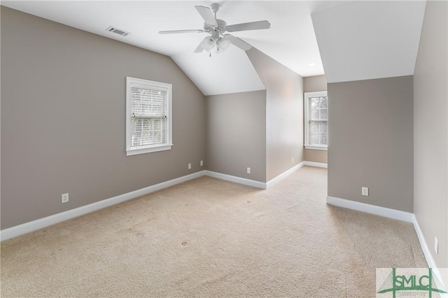 bonus room with lofted ceiling, light carpet, and ceiling fan