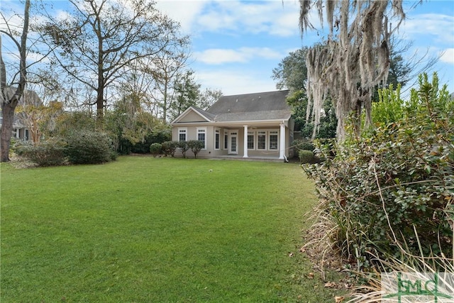 rear view of property featuring a lawn