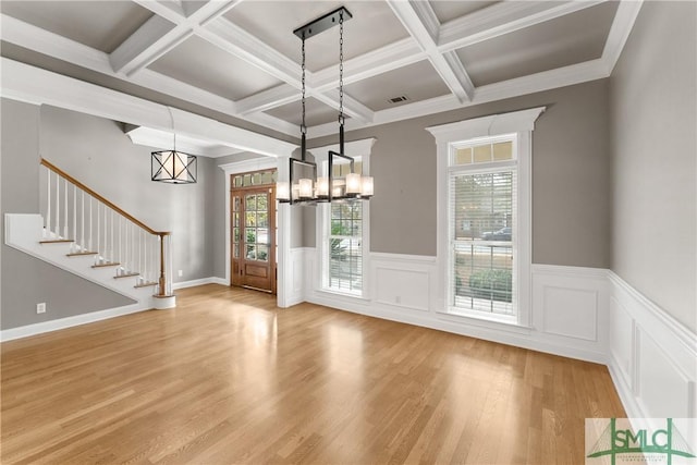 unfurnished dining area featuring beamed ceiling, plenty of natural light, coffered ceiling, and light wood-type flooring