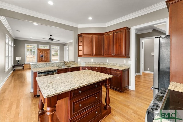 kitchen featuring sink, appliances with stainless steel finishes, a kitchen breakfast bar, light stone counters, and kitchen peninsula