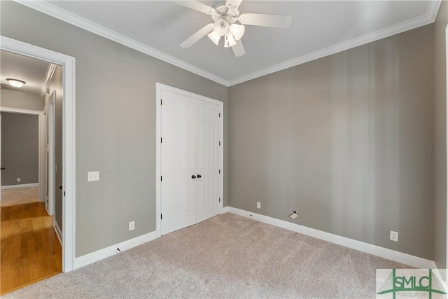 unfurnished bedroom featuring crown molding, carpet flooring, and a closet