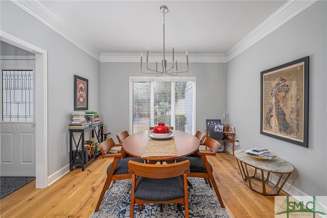 dining space with crown molding, wood-type flooring, and a chandelier