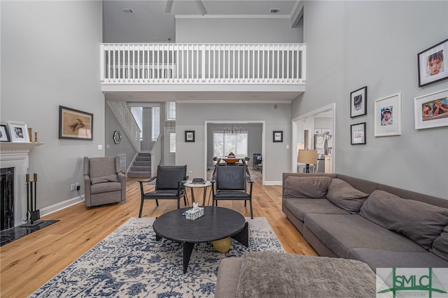 living room featuring a high ceiling, crown molding, and hardwood / wood-style floors