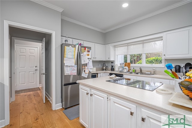 kitchen featuring sink, crown molding, stainless steel fridge, black electric stovetop, and white cabinets