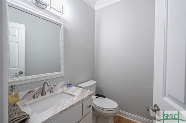 bathroom featuring crown molding, vanity, toilet, and wood-type flooring